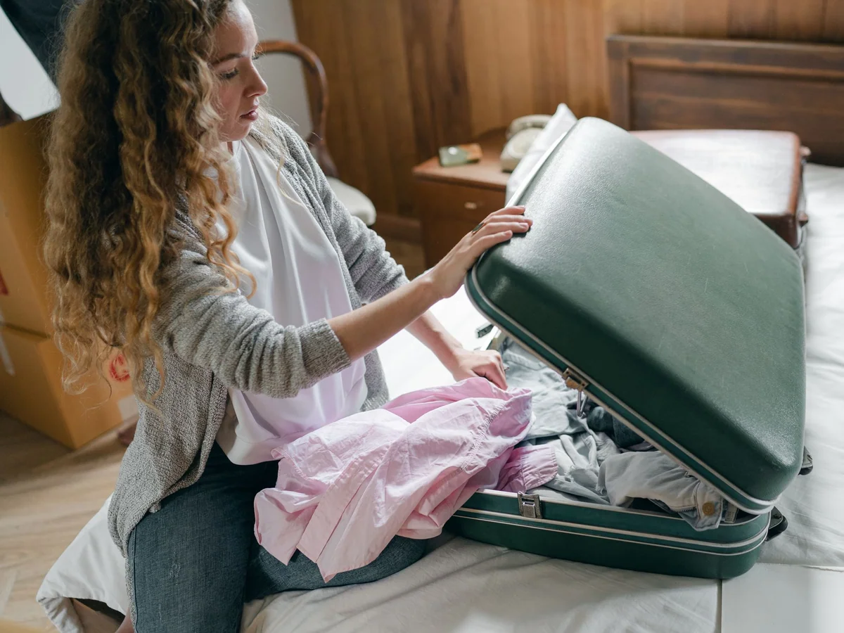 Woman organizing a compact carry-on wellness kit before an overnight flight