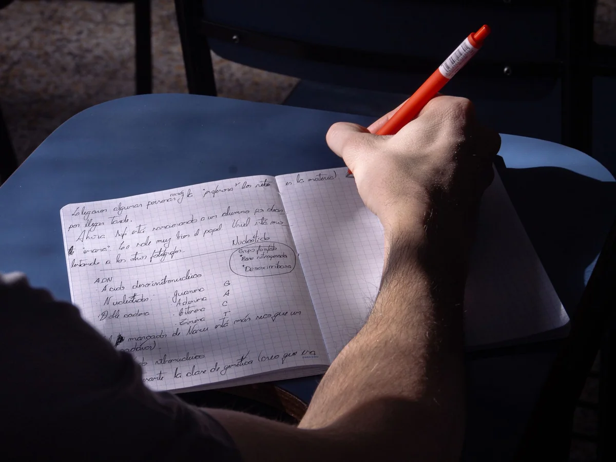 Woman writing briefly in a compact notebook at home