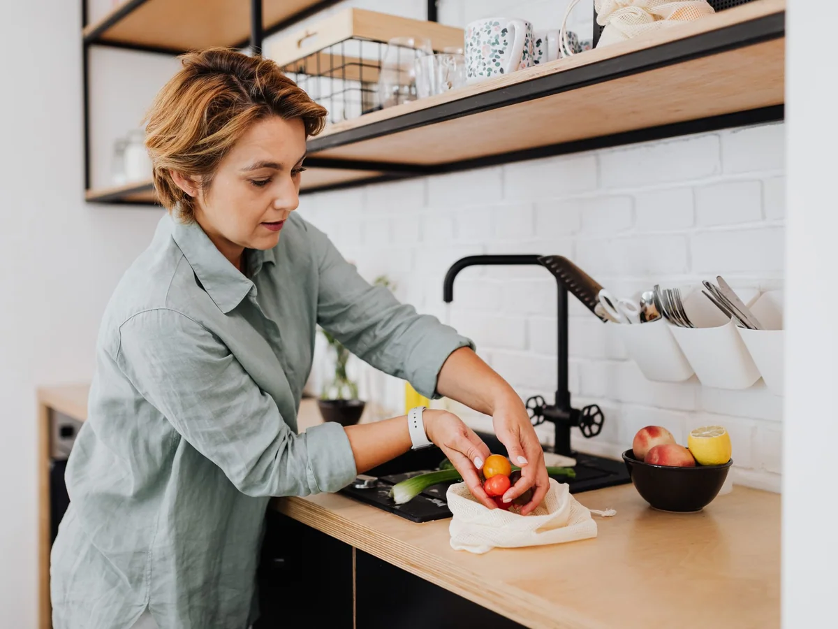 Woman packing prepared meals into stackable containers