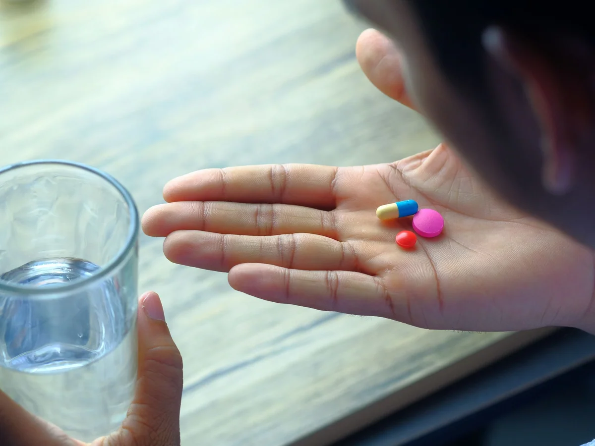 Woman organizing medication reminders at a kitchen counter